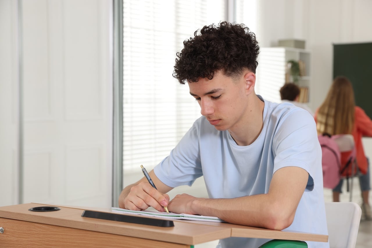 Exam Stress Is Real: How Students Can Maintain Balance During Exam Season Group of students studying at wooden desks in classroom, selective focus Exam Stress Is Real: How Students Can Maintain Balance During Exam Season